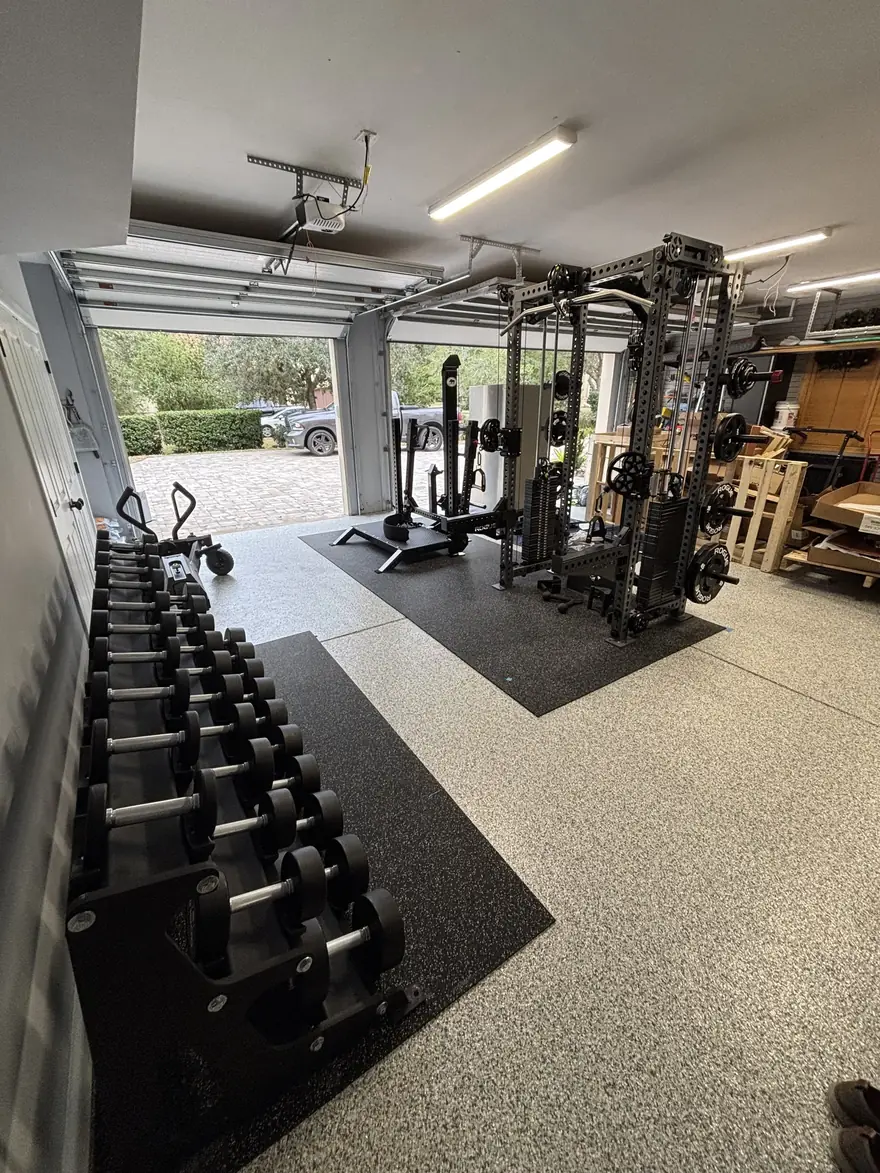 Home gym with a power rack and dumbbells assembled in a Jacksonville, FL garage